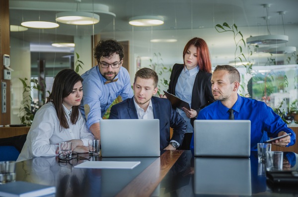 A group of developers in the office coding and discussing the problem, Showing journey from a single developer to a team